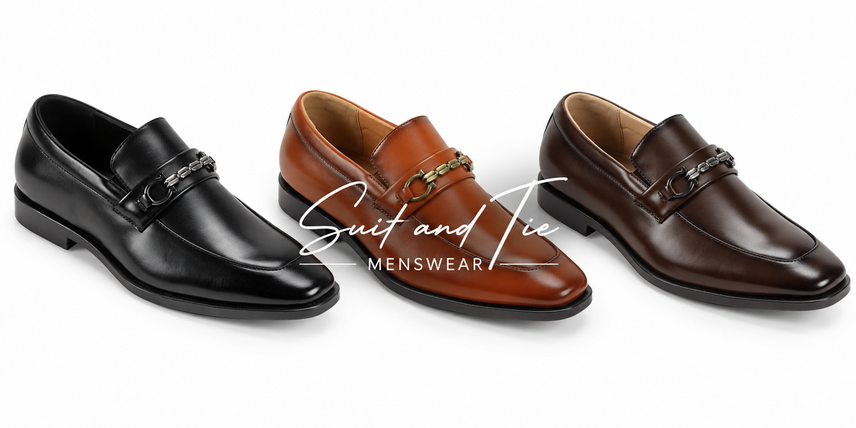 Three men's leather penny loafers shown on a white background: one black, one tan-brown, and one dark brown. A white script logo reading 'Suit and Tie MENSWEAR' is overlaid across the center.