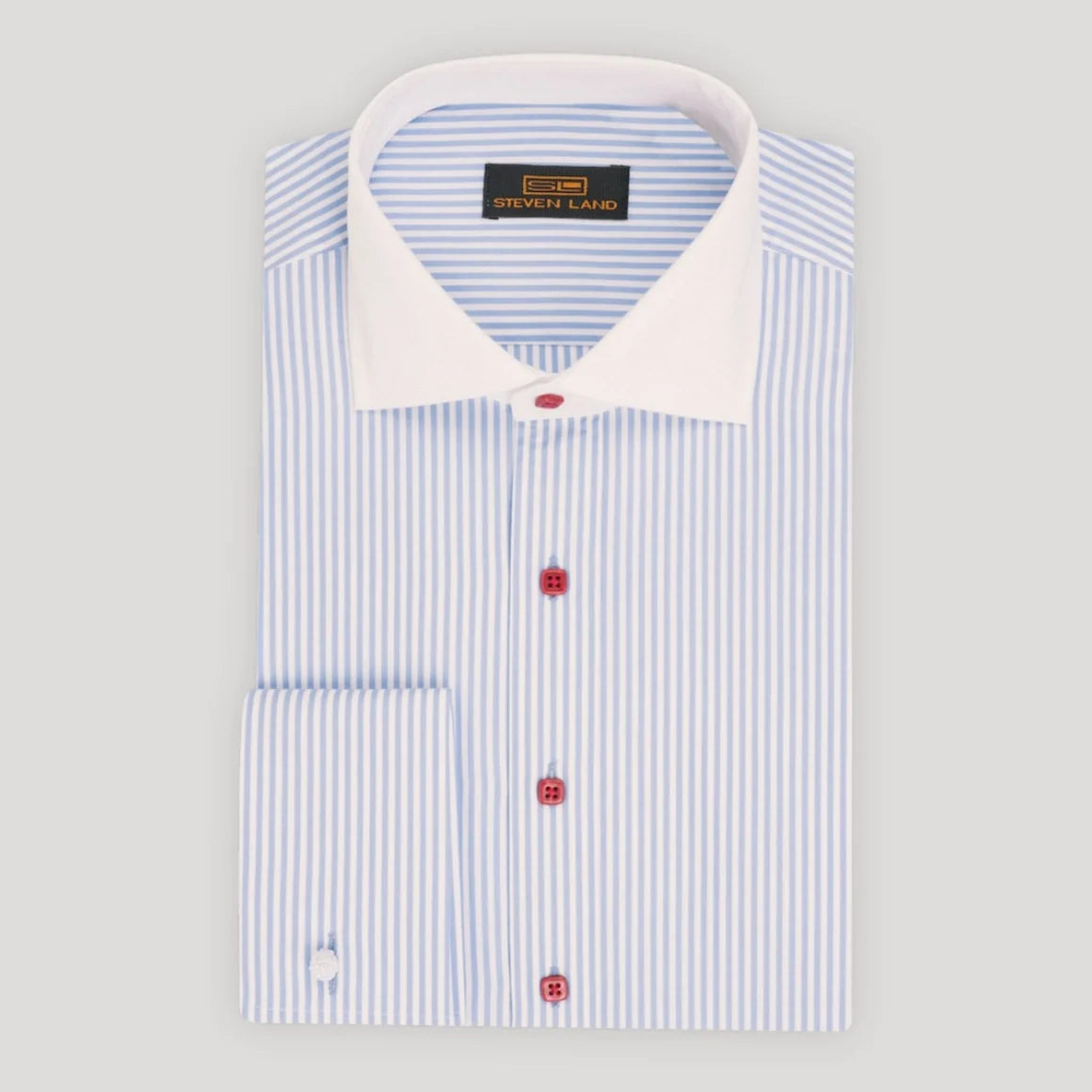 A folded dress shirt with light blue and white vertical stripes, featuring a solid white collar and red buttons, displayed on a neutral light gray background.